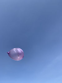 Low angle view of balloon against blue background