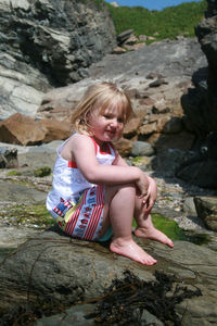 Boy on rock at shore