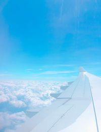 Aerial view of airplane wing against blue sky