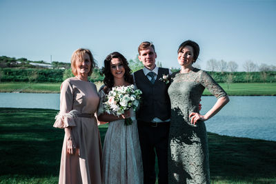 Portrait of happy friends standing against the sky