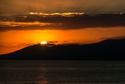 Scenic view of sea against romantic sky at sunset