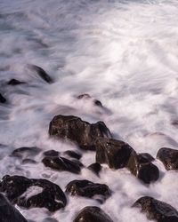 Scenic view of rocks in sea against sky