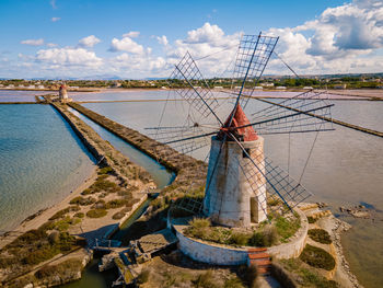 Traditional windmill on land against sky