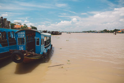 Boats moored on river against sky