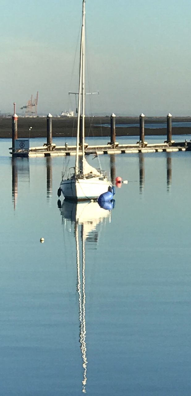 water, nautical vessel, transportation, mode of transportation, waterfront, reflection, sea, moored, sky, no people, nature, sailboat, day, tranquility, mast, pole, outdoors, clear sky, scenics - nature, yacht, marina, wooden post