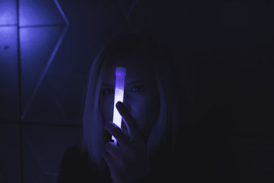 Woman holding glowing equipment at night