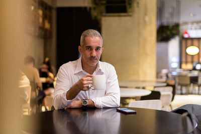 Portrait of man sitting at restaurant table