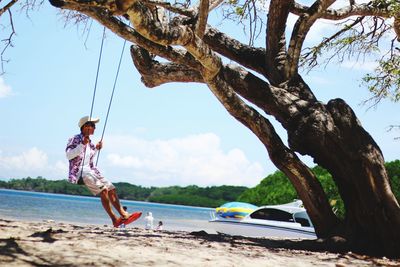 Low angle view of man skateboarding on beach against sky