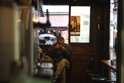 People looking through window at store