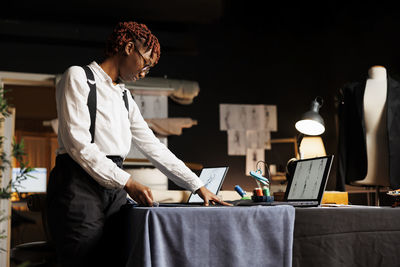 Side view of man using laptop at home