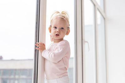 Portrait of boy standing against wall