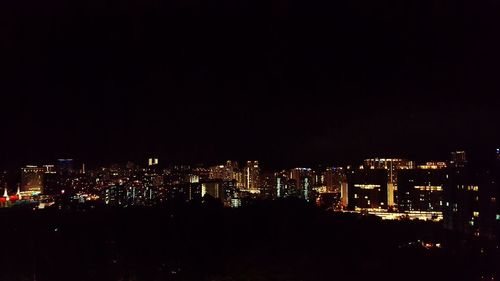 Illuminated cityscape against sky at night