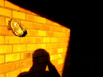 Shadow of man walking on yellow wall