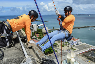  man with helmet, glove and equipment practicing rappel 