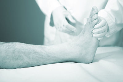 Midsection of doctor examining leg