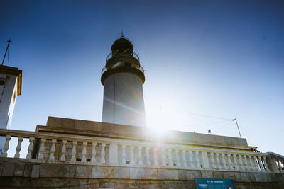 Low angle view of lighthouse against buildings