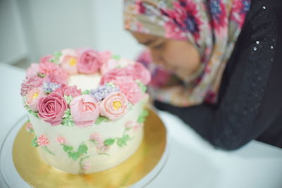 High angle view of woman decorating cake at table