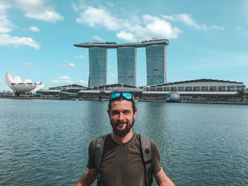 Portrait of smiling man against marina bay sands in city