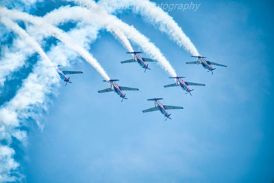 Low angle view of airplane flying against blue sky