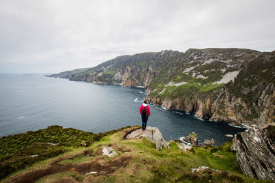 Rear view of woman looking at sea against sky