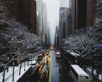 Snow covered road in city