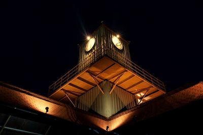 Low angle view of illuminated building against sky at night