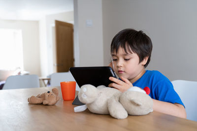 Boy with toy on table at home