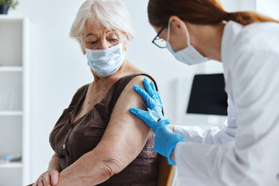 Doctor vaccinating senior patient at clinic