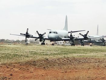 Airplane on airport runway against sky