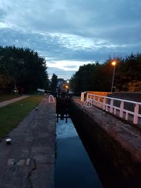 Road by trees against sky