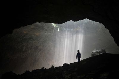 Low angle view of man standing in cave