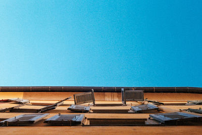 Chairs and tables against swimming pool against clear blue sky