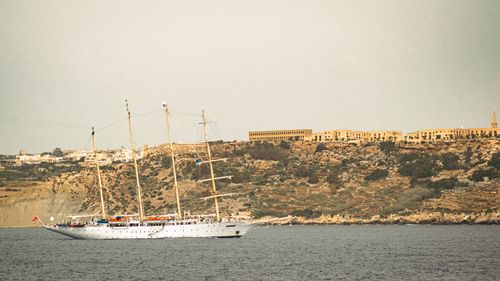 Boats in sea against clear sky