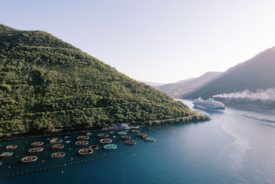 Scenic view of sea and mountains against clear sky