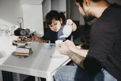 Father and daughter having tea party