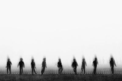 Multiple image of person on field against clear sky