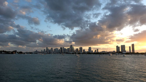 Panoramic view of sea and buildings against sky during sunset