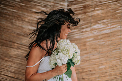 Side view of woman standing against pink flower