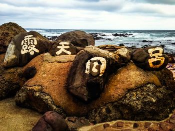 Close-up of rocks on beach against sky