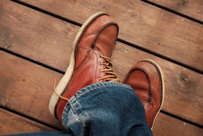 Low section of man standing on hardwood floor