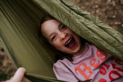 Overhead of young girl in hammock laughing