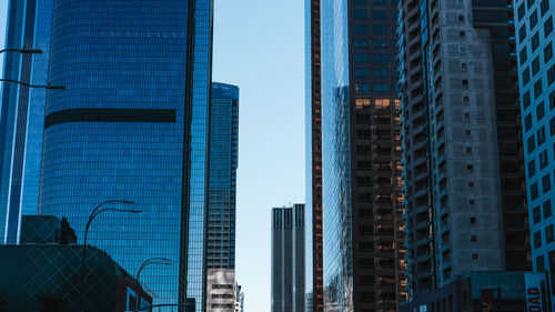 Low angle view of modern buildings against blue sky