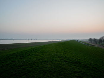 Scenic view of field against clear sky during sunset