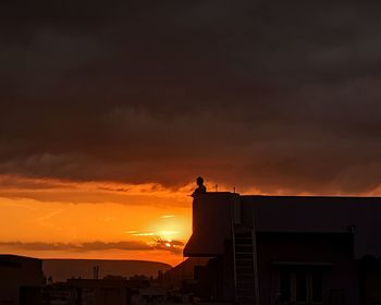 Low angle view of silhouette buildings against sky during sunset
