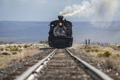 Train on railroad track against sky