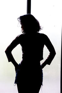 Rear view of silhouette woman standing against white background