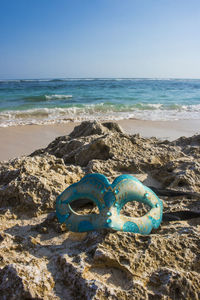 Blue sea shore on beach against clear sky