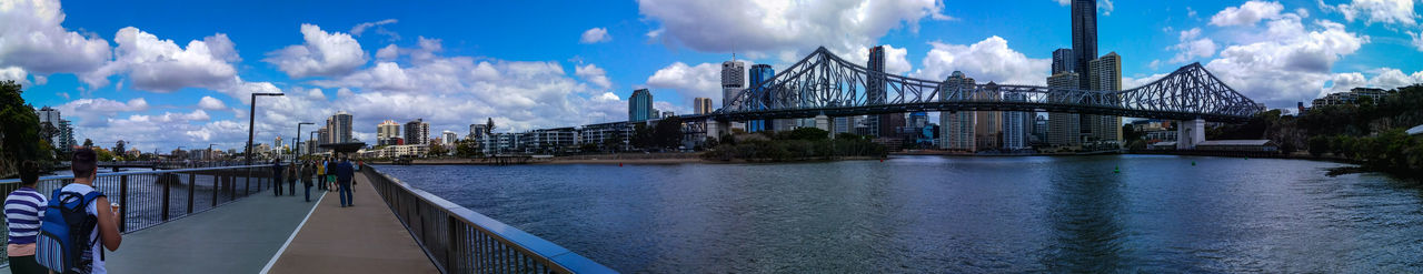 Bridge over river against cloudy sky