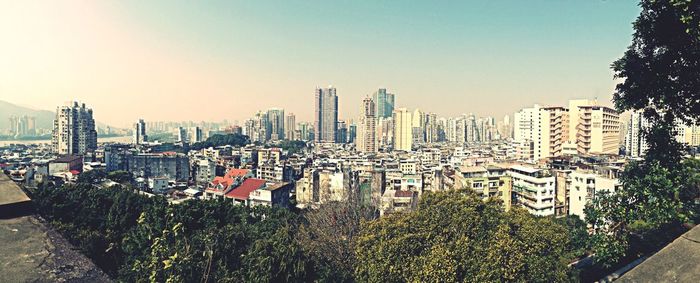 Buildings in city against clear sky