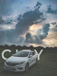 Car on field against sky during sunset